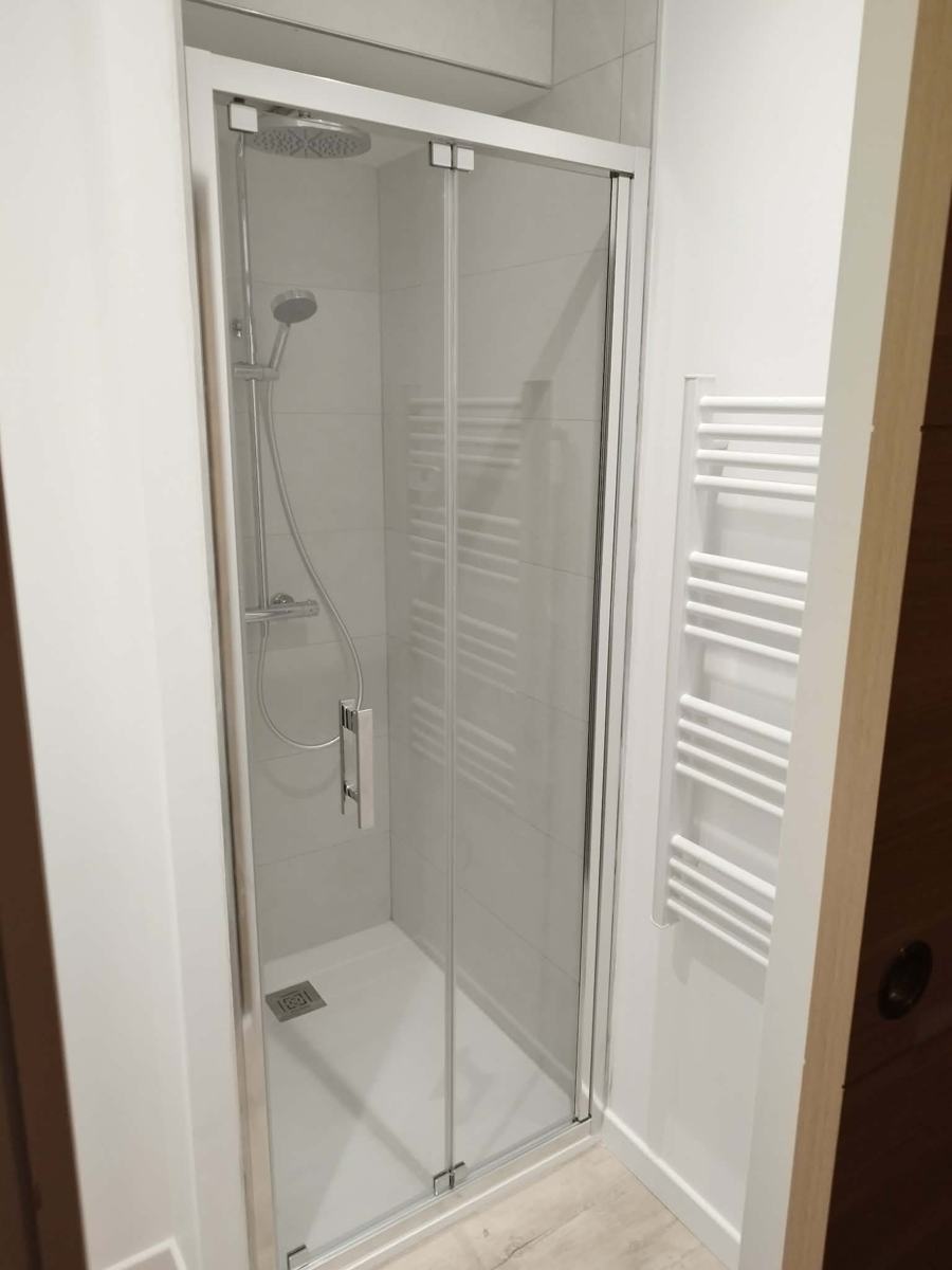 Douche avec porte pivotante et colonne de douche installées à Pau